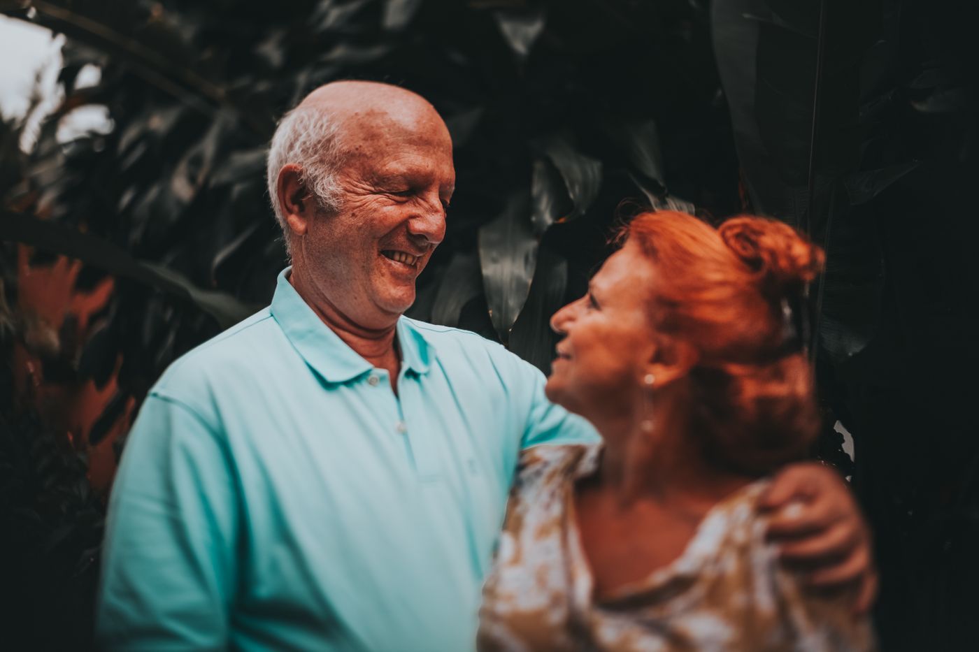 Pareja de unos 60 años sonriendo al aire libre