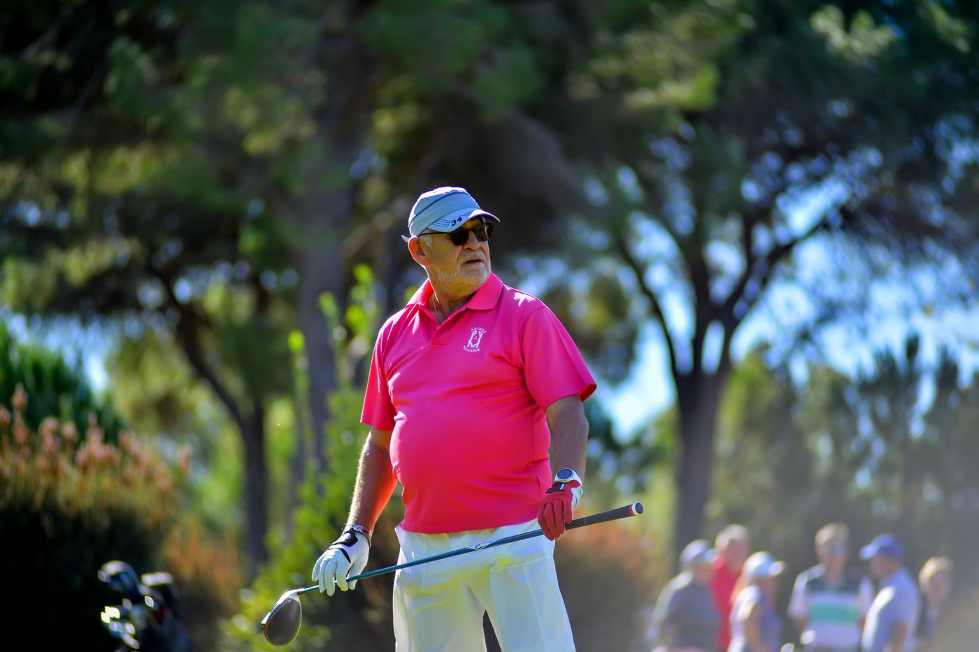 Hombre mayor sonriente con palo de golf